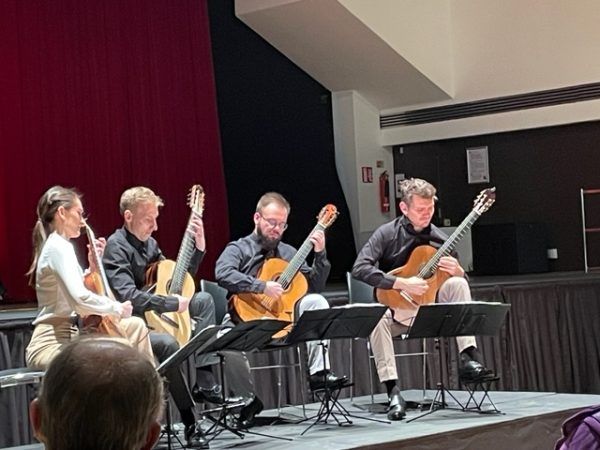 Erlendis Guitar Quartet performing on stage with music stands in front of them