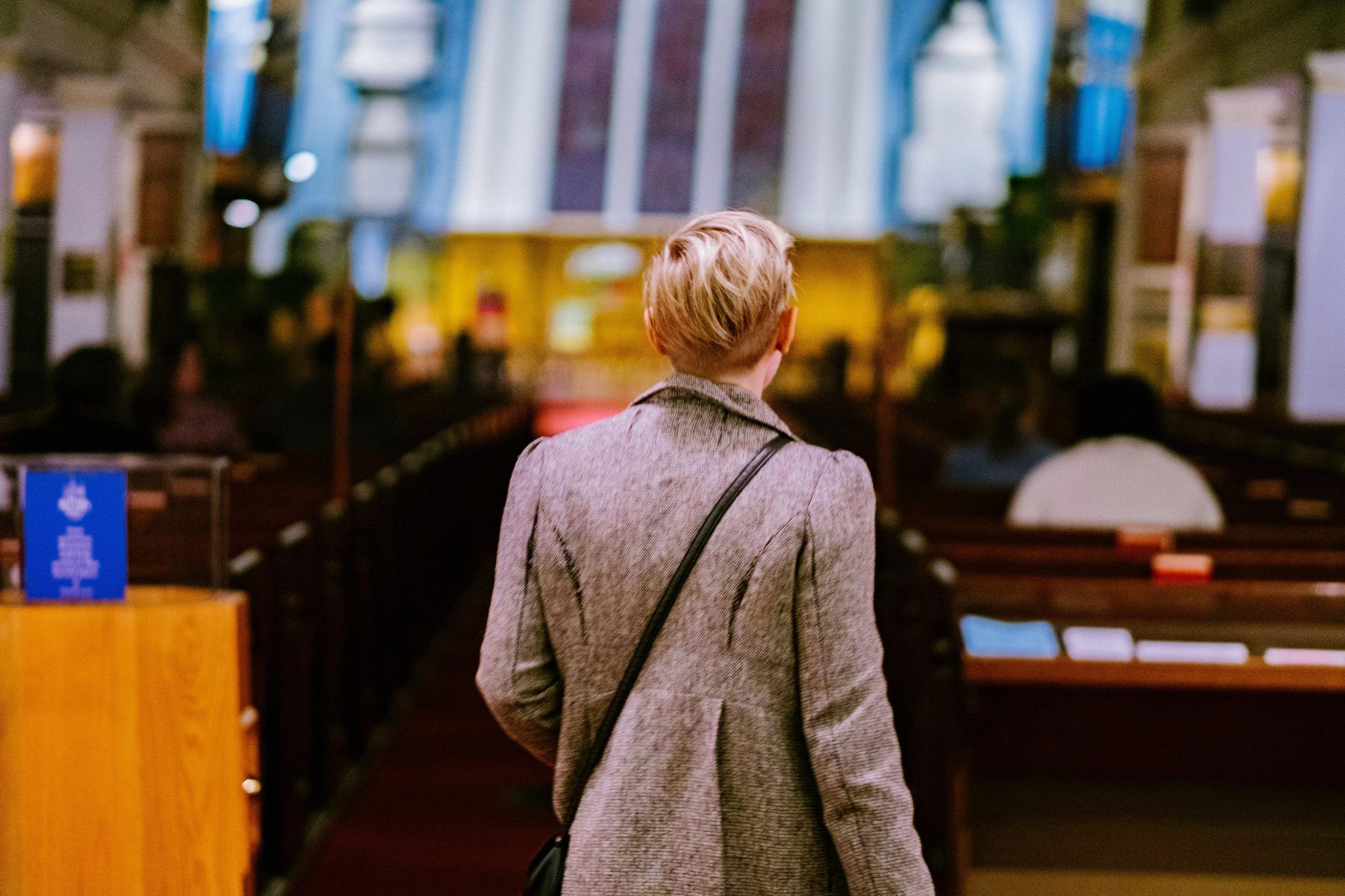 A shallow depth photo taken from behind a person entering a church