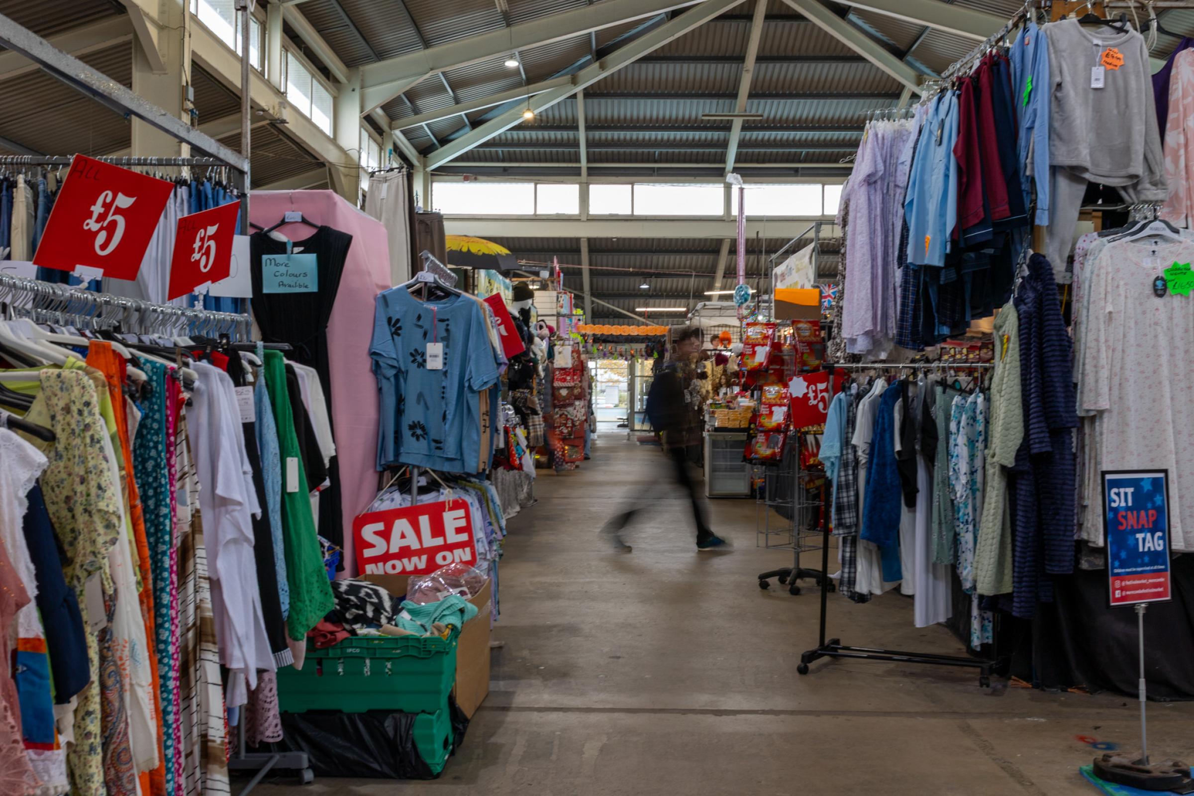 A blurred image of a person working through an indoor market