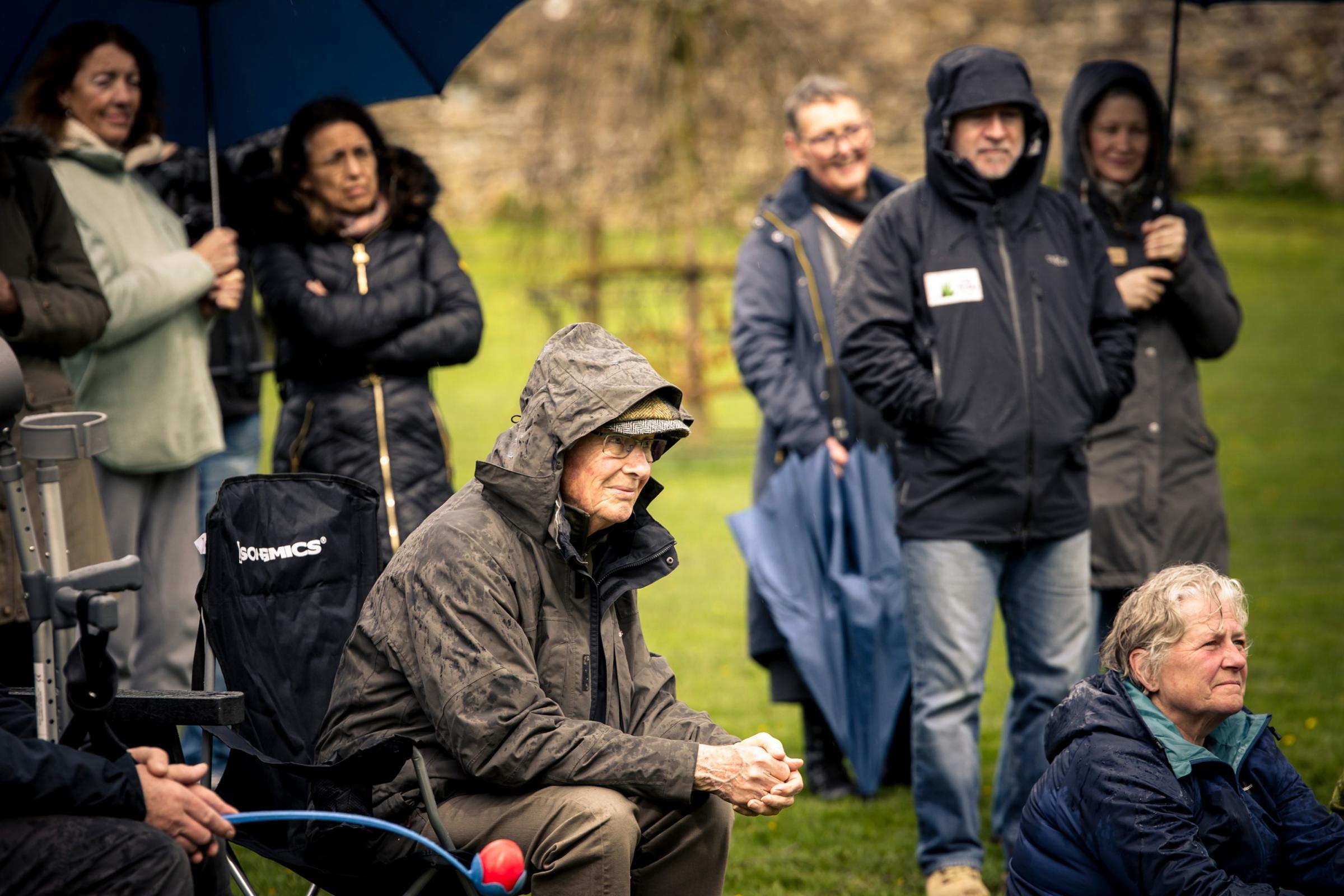 Audience watching a performance in the rain