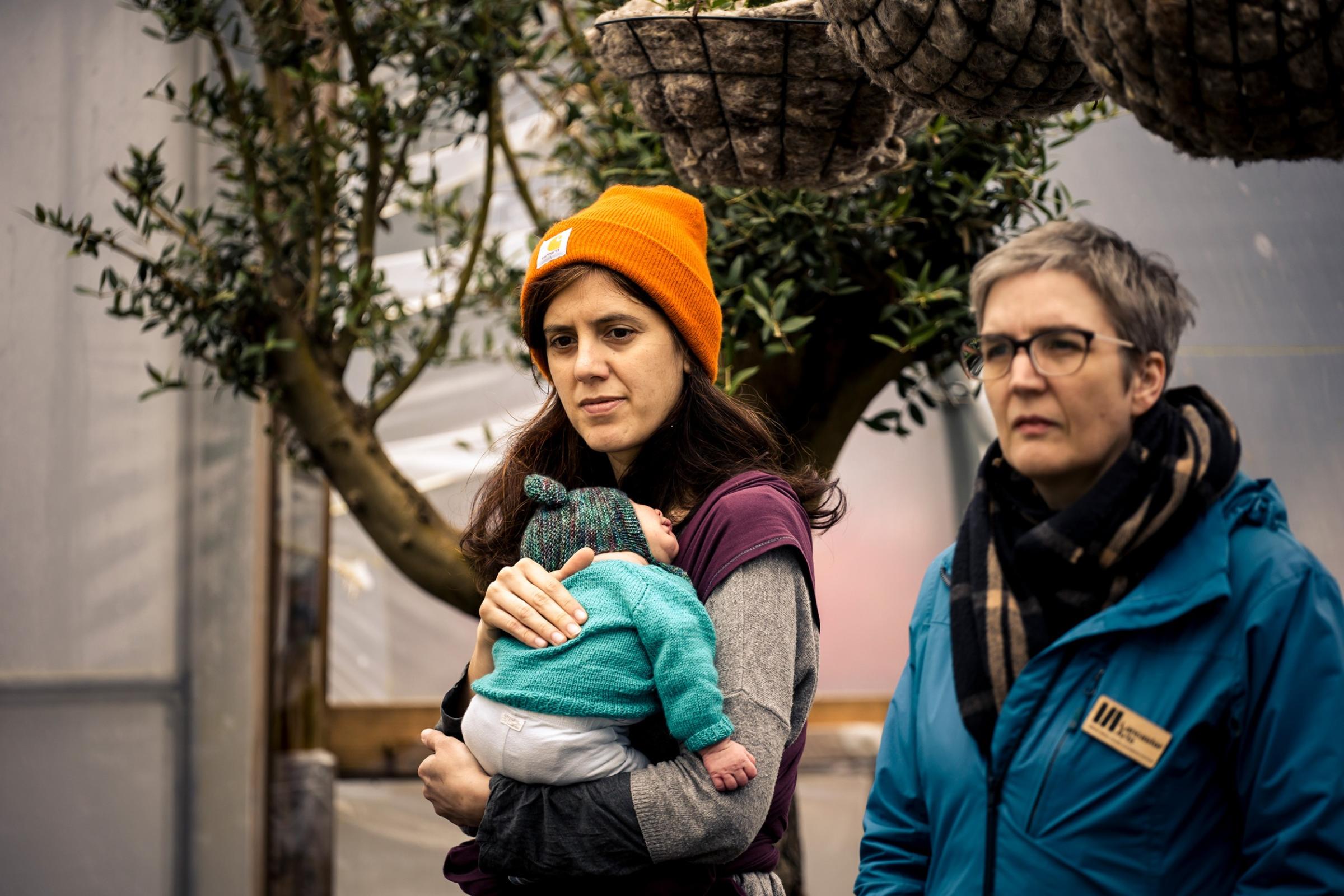 Two women, one holding a baby