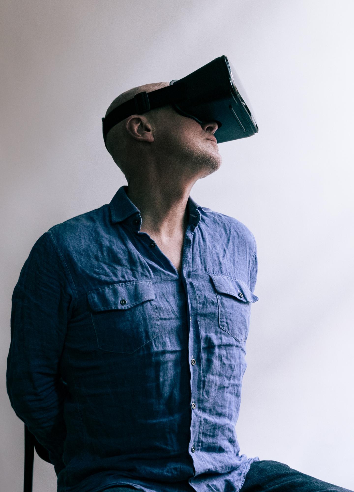 A man sitting down wearing a virtual reality headset
