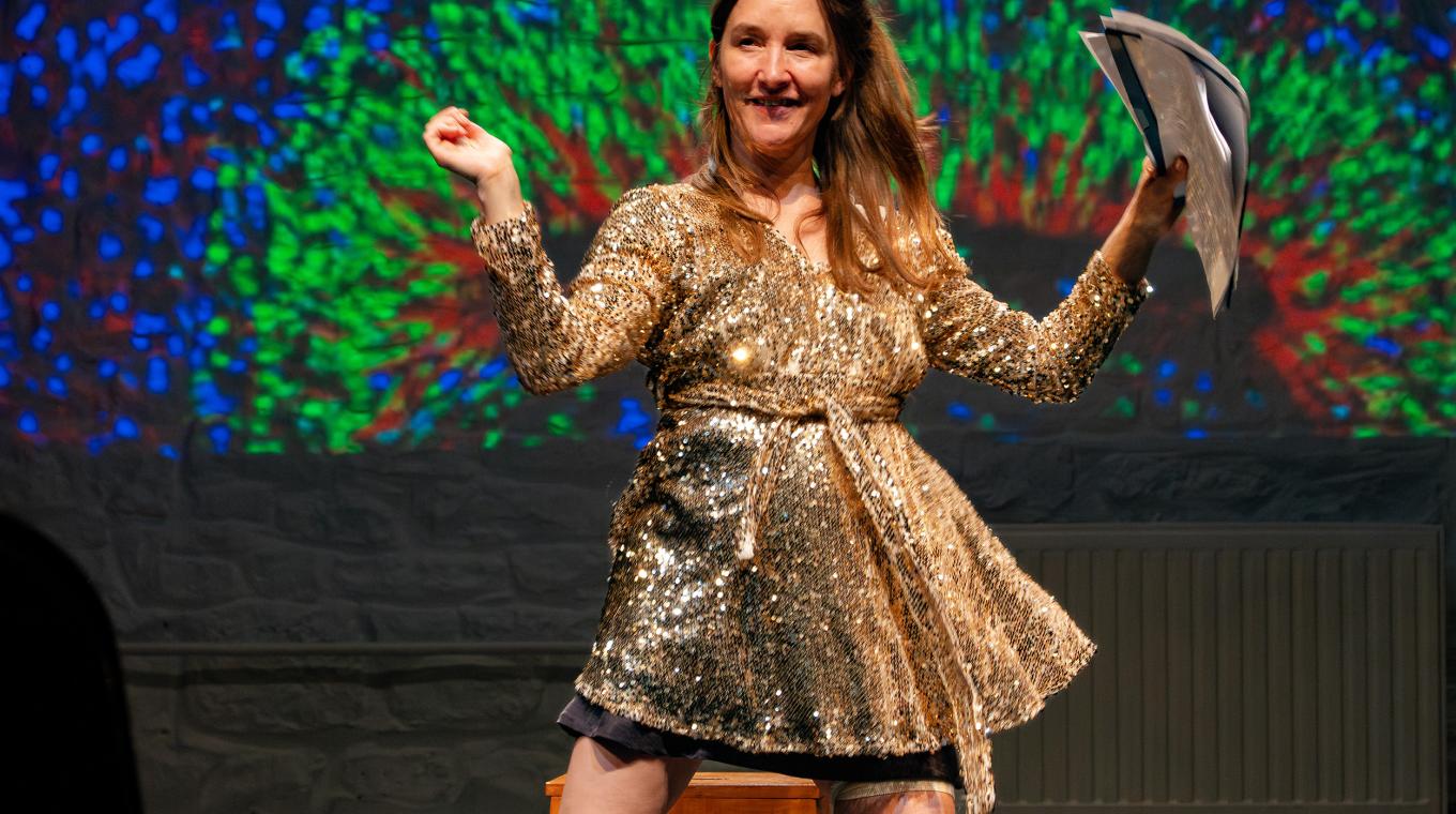 A woman dancing with a colourful screen behind