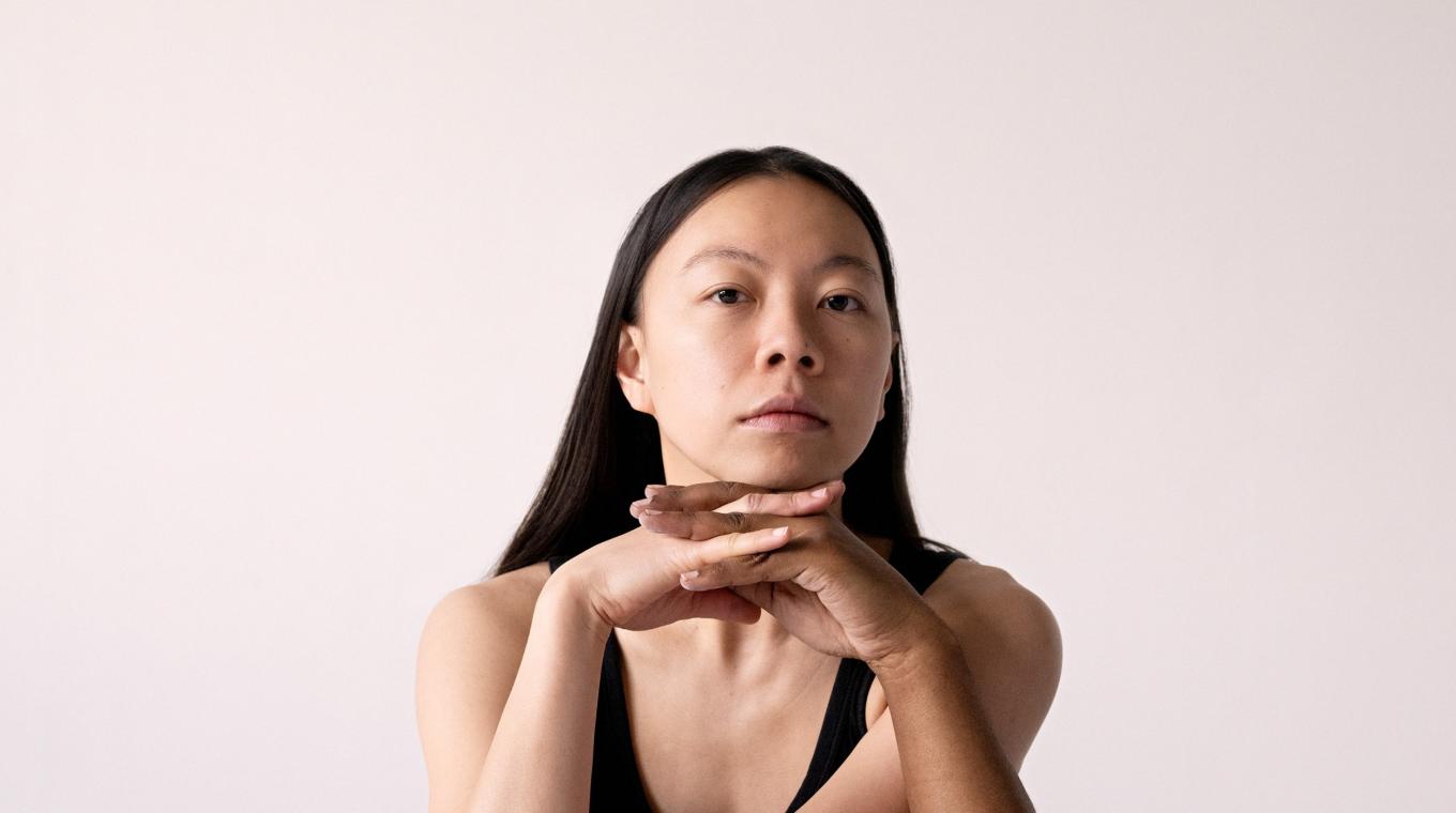 A woman seemingly with three arms and four juggling balls