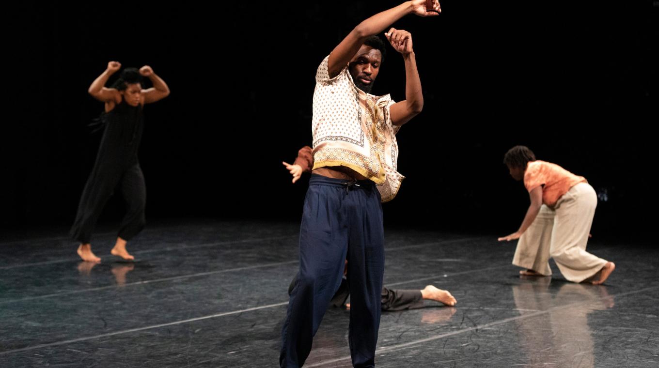 A male dancer with arms above his head