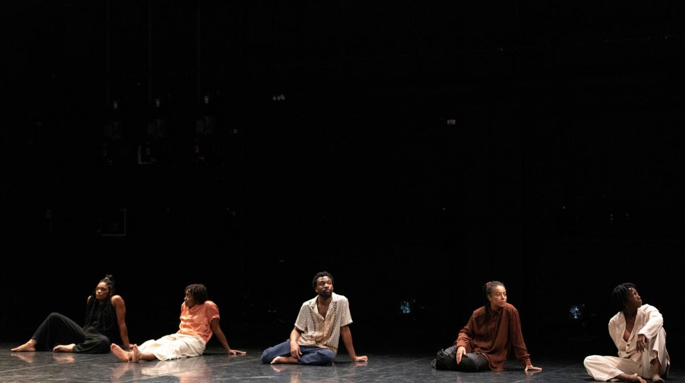 Five dancers sitting on the floor