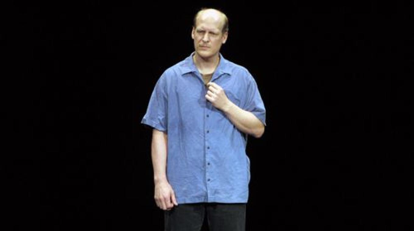 A male performer with a blue shirt stood on stage