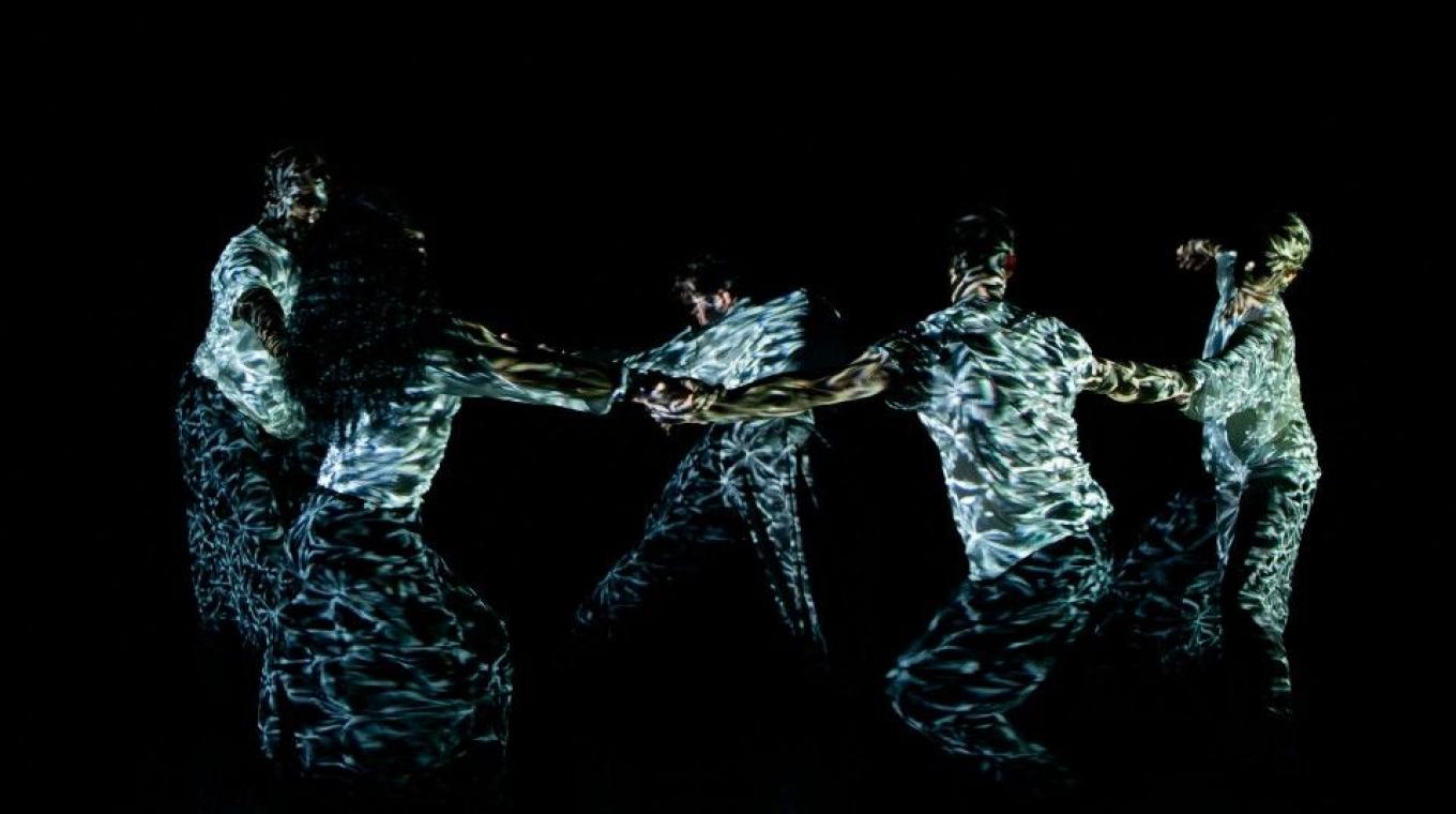 performers on stage holding hands