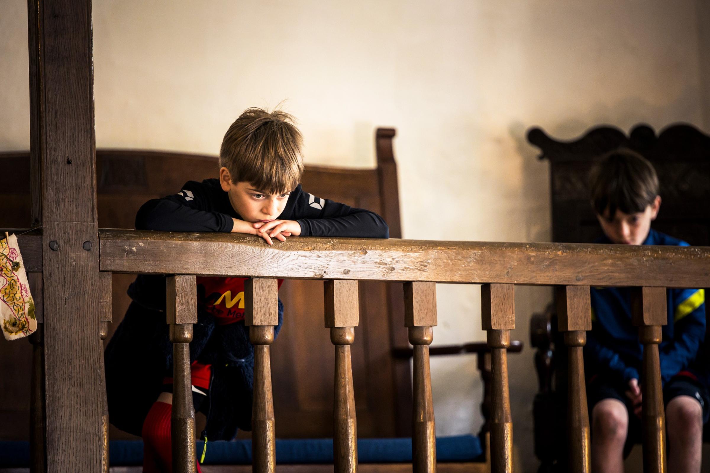 Two boys watching a performance from a balcony