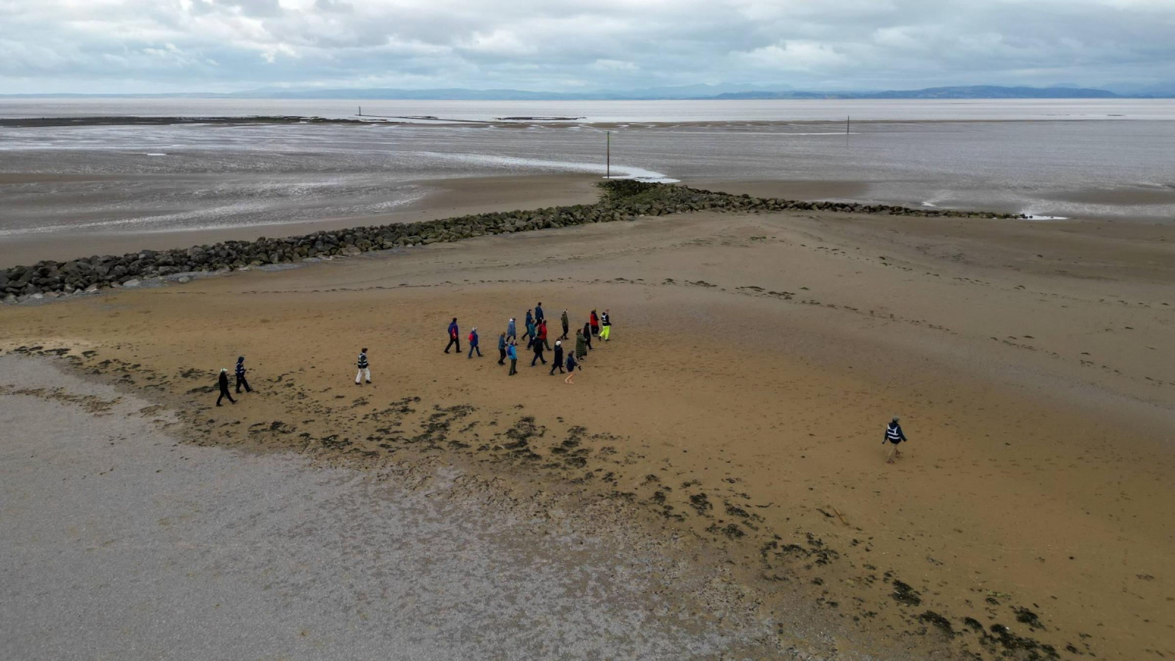 Aerial shot of people walking on a beach
