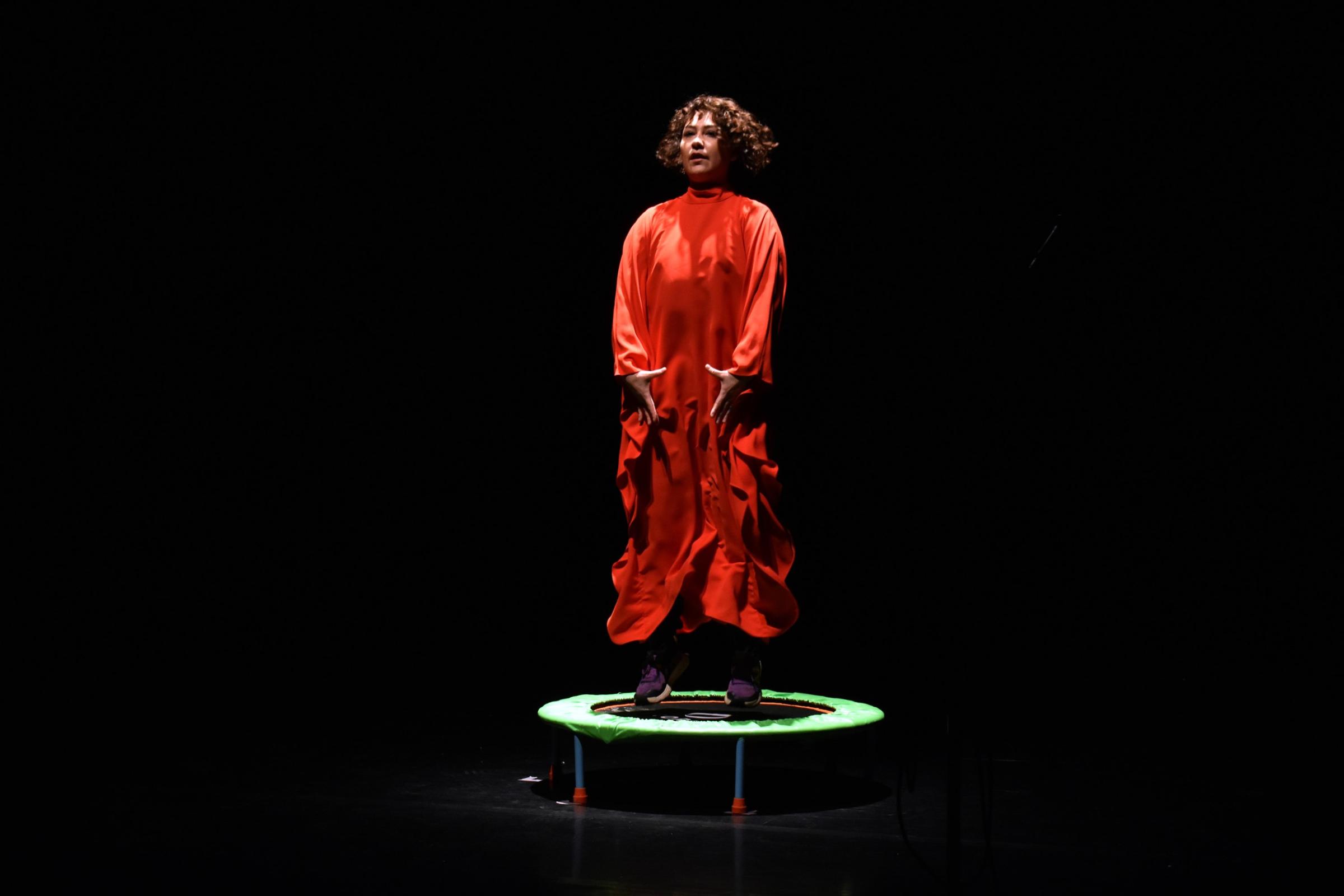A woman in red jumping on a mini trampoline