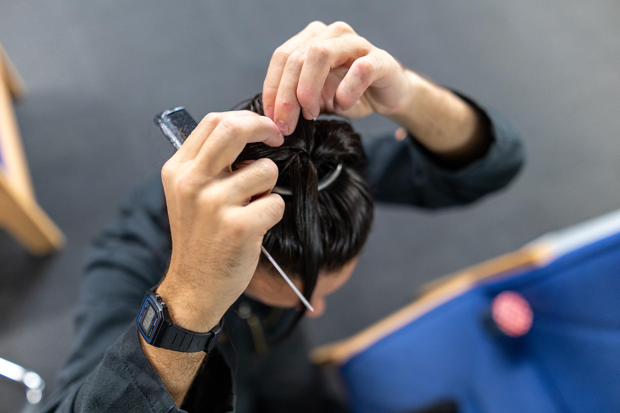 A man tying his hair up