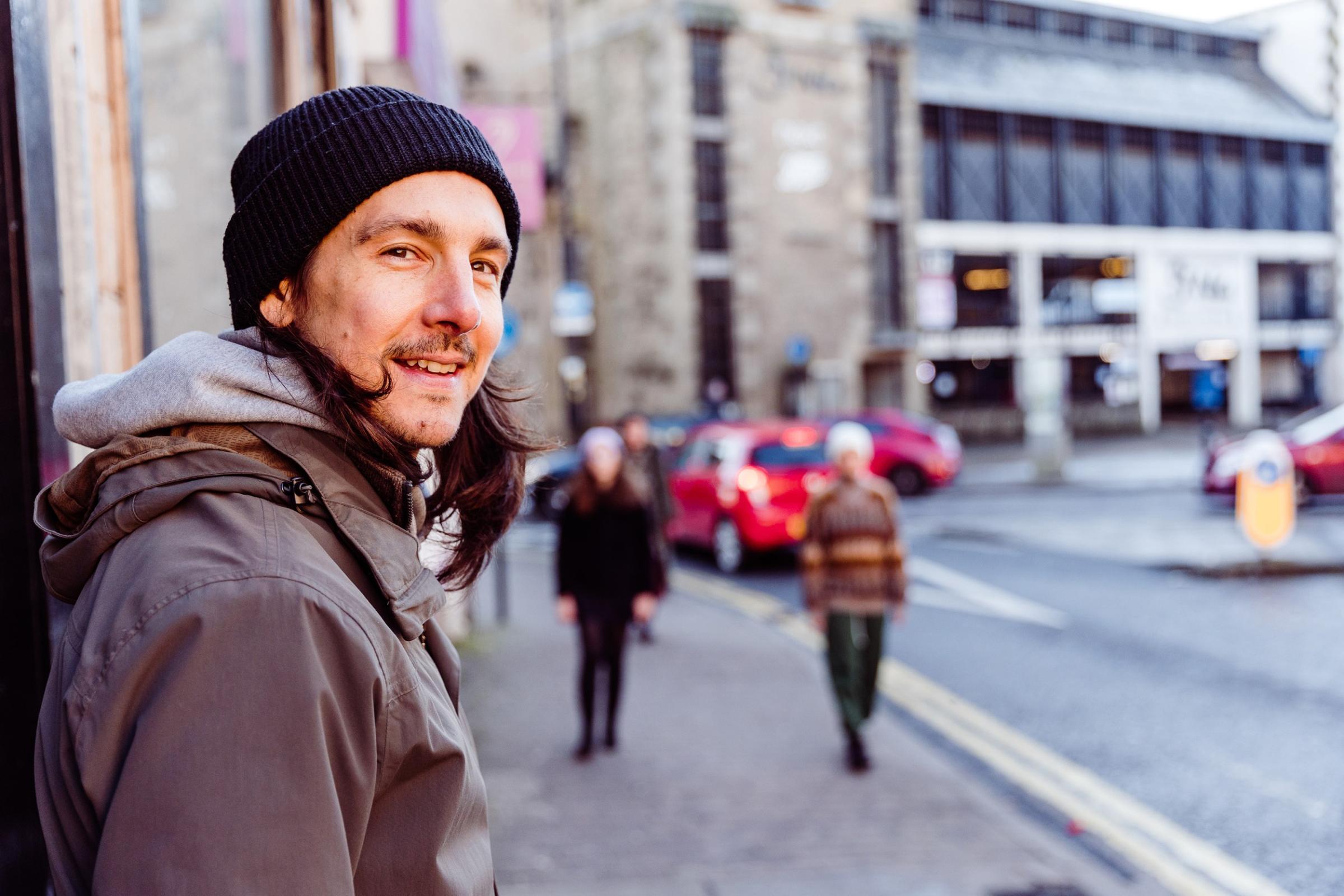 A man in a wooly hat smiling