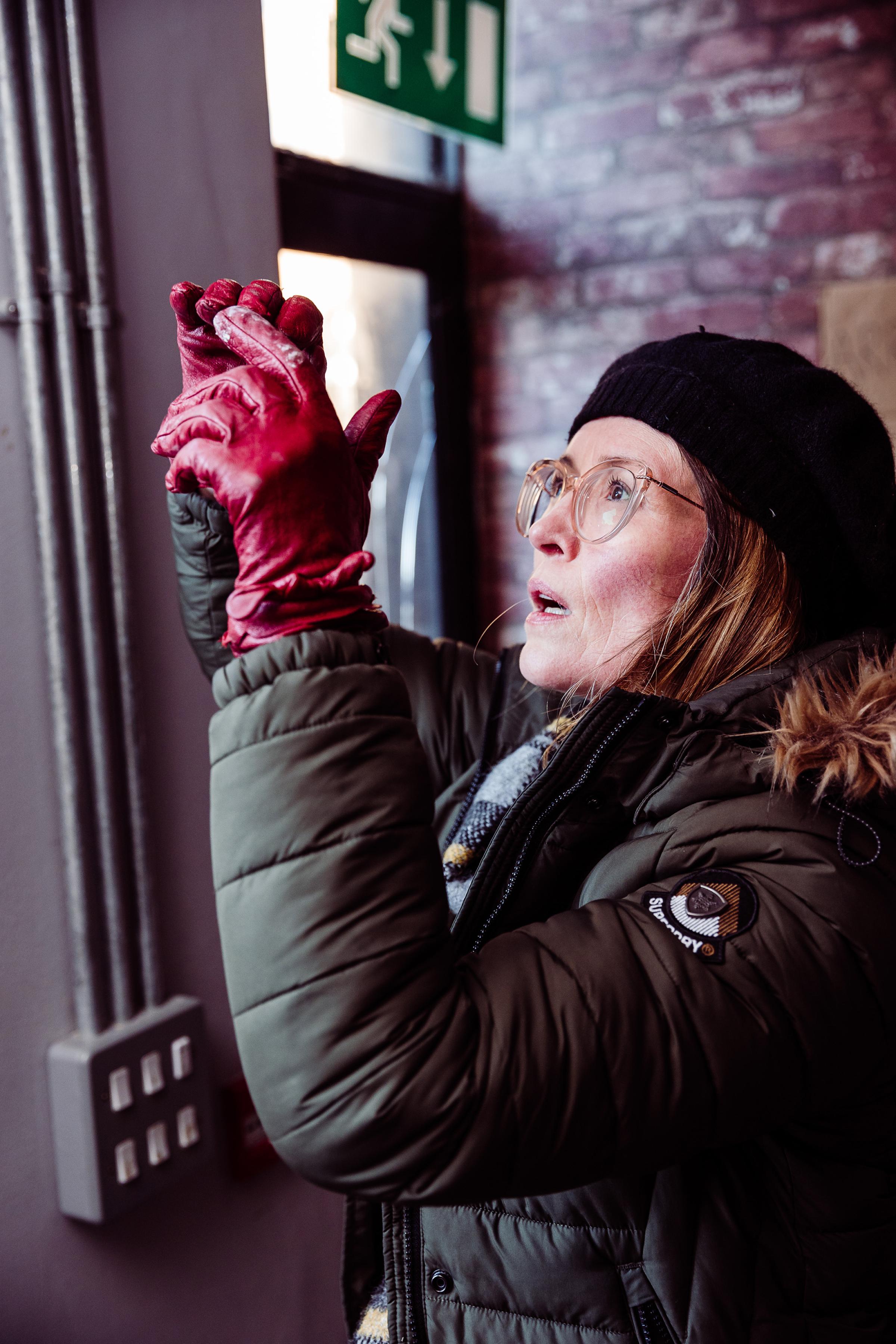 A woman with red gloves taking a photo