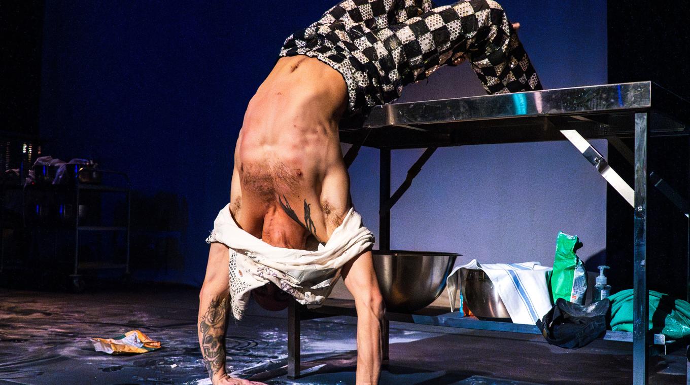 a bend bending backwards over a table with flour on the floor