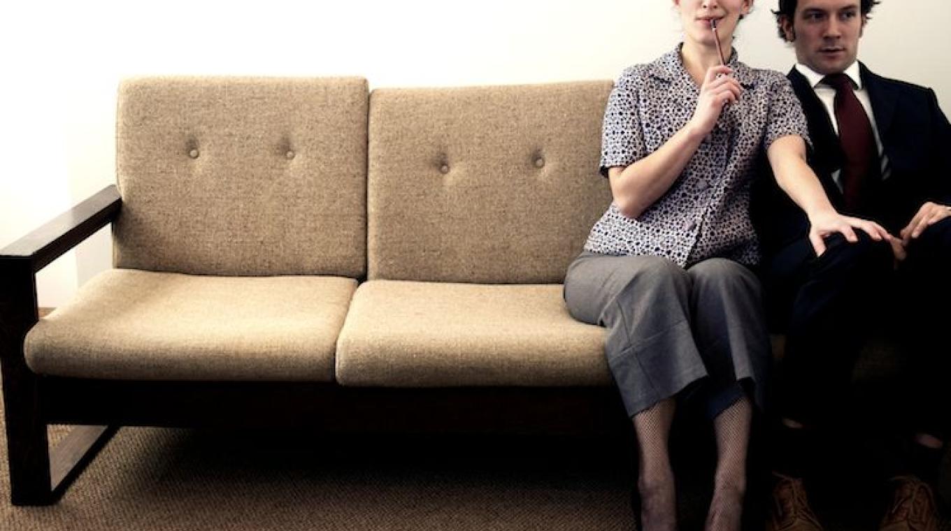 A man and a woman sat on a couch.