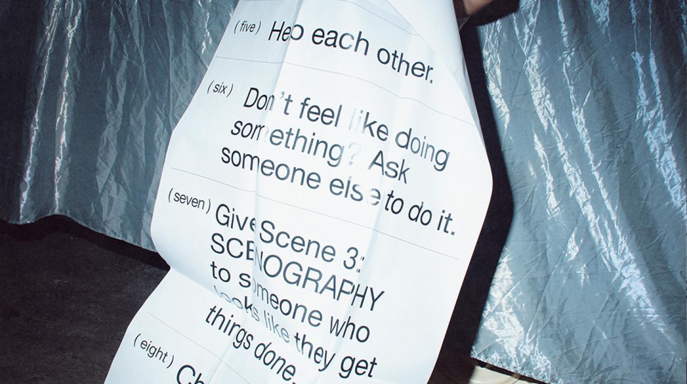 A person holding a huge piece of paper covering their body with instructions on it