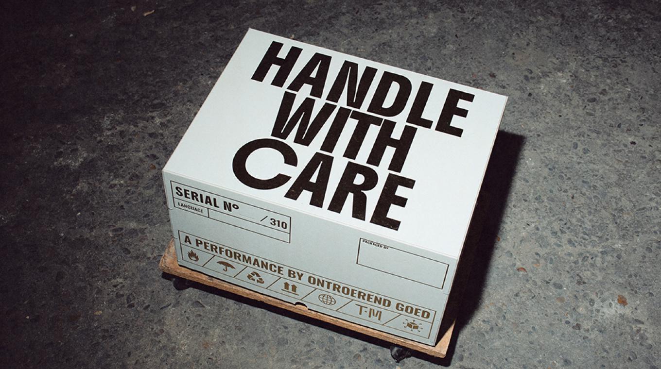 A large white box with the words "Handle with Care" on top