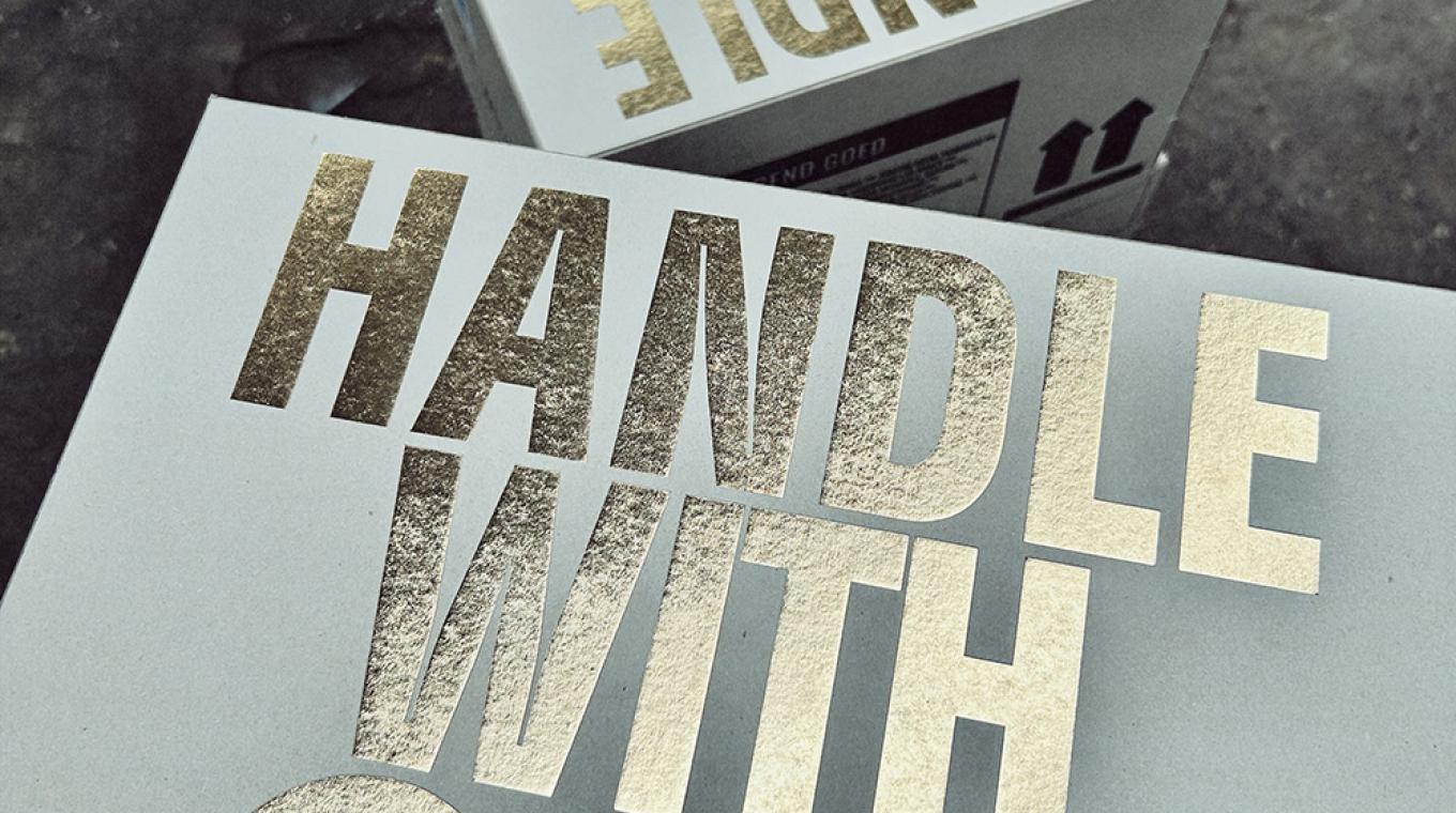 Two large white boxes with "handle with Care' written on tope in bold shiny type face