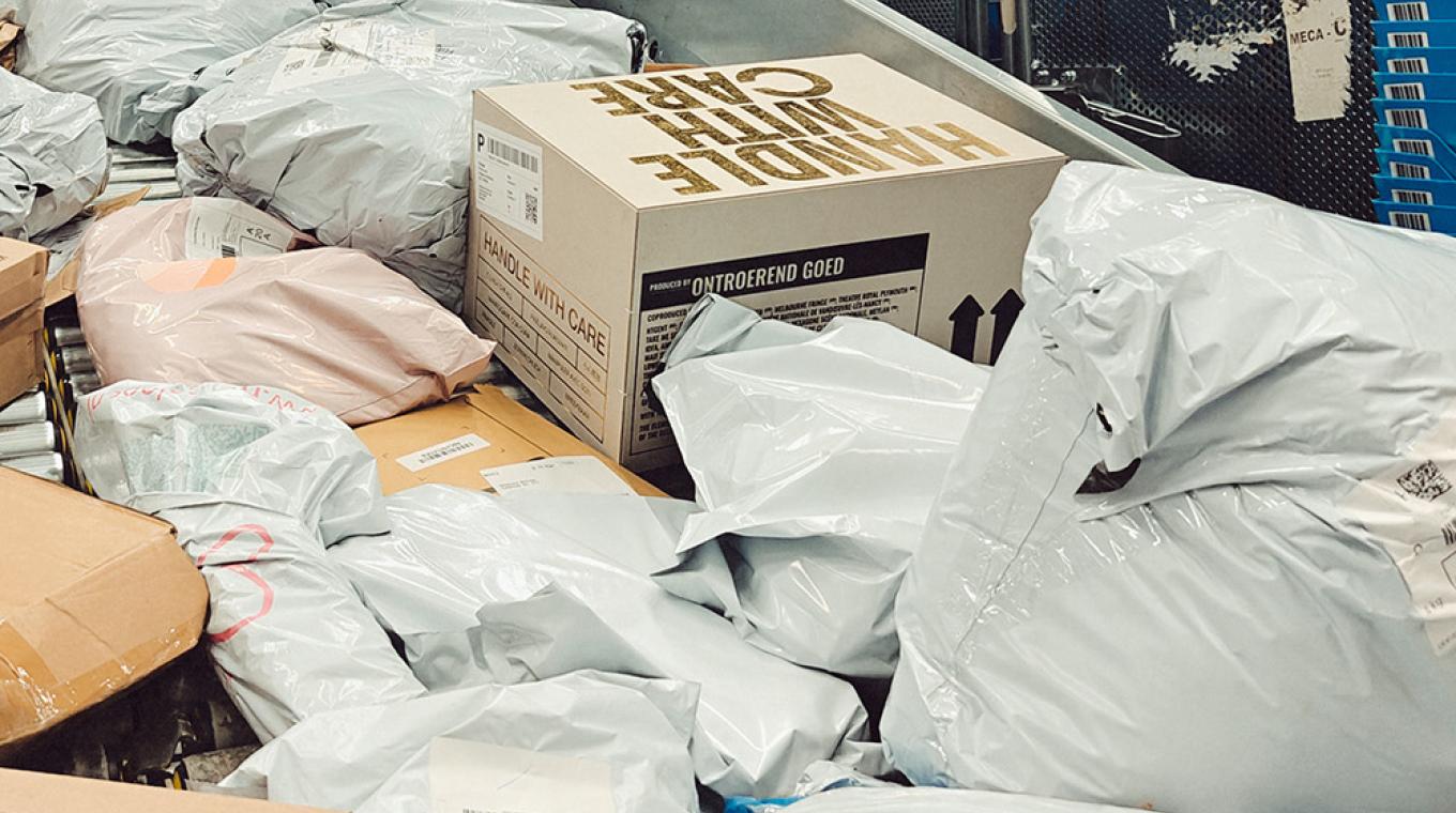 A post office shoot filled with parcels including a box that says "Handle with Care"