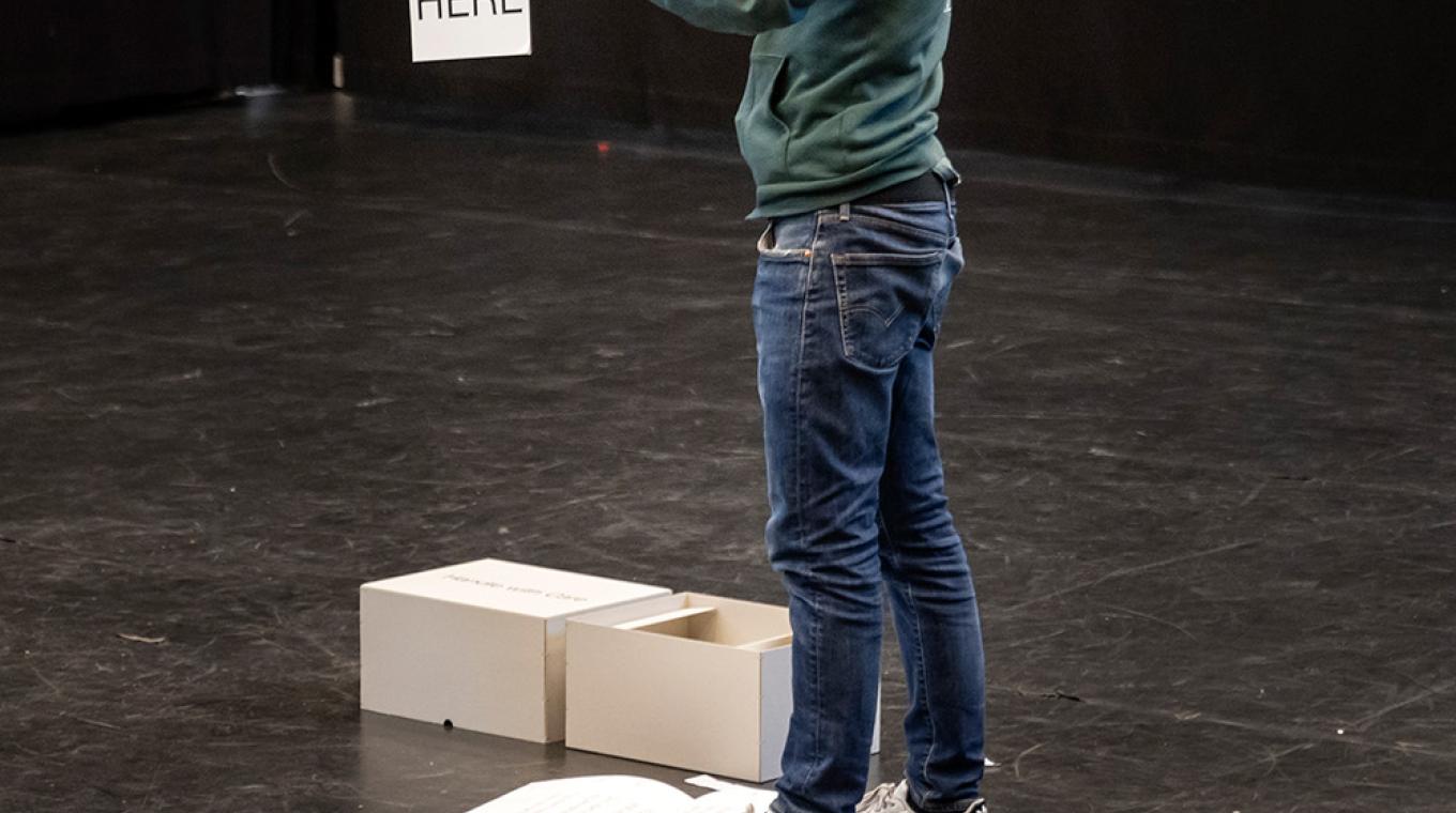 A man pegging a piece of card on a piece of string
