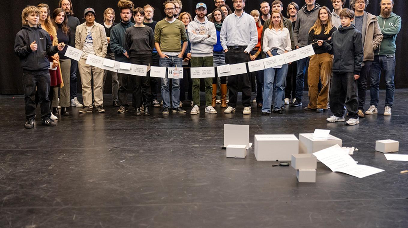 A large group of people stood behind a long peuec of string with different cards hanging on it