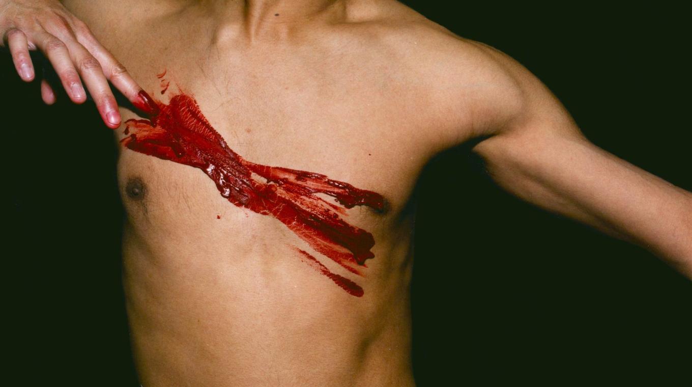 Red Paint marks on the front of a man's bare chest