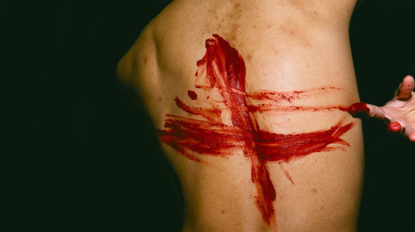 Red Paint marks on the back of a man