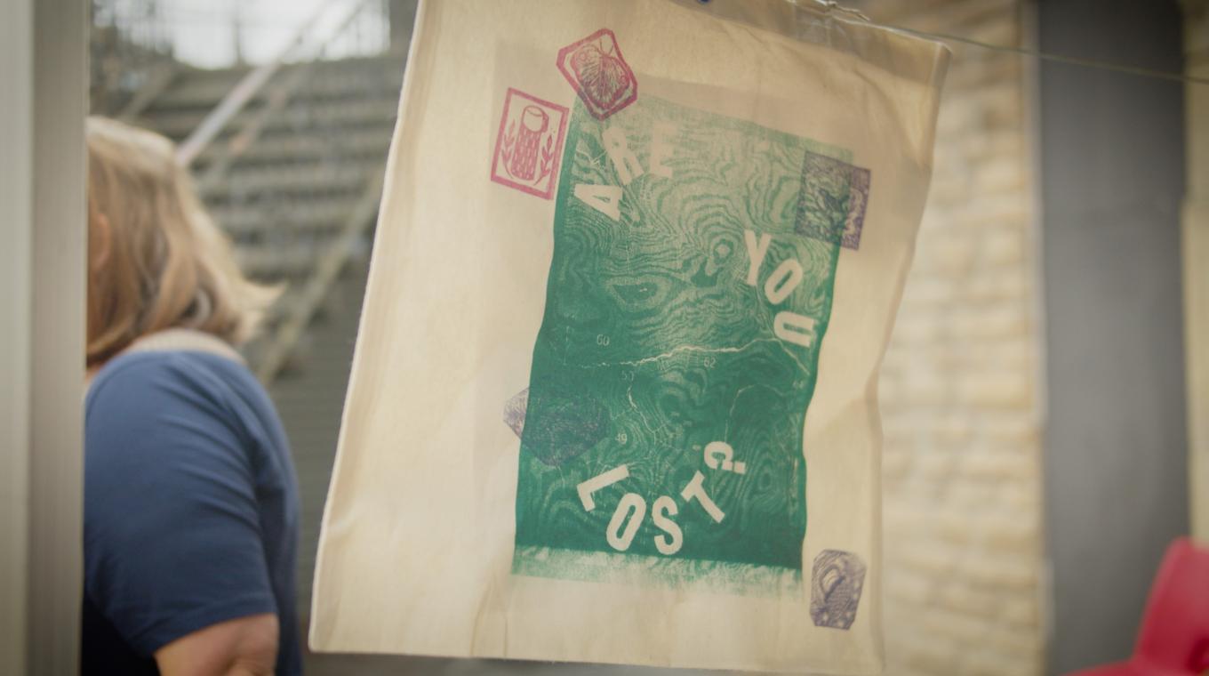 A screenprinted tote bag on a line with the words 'Are You Lost?' printed on it