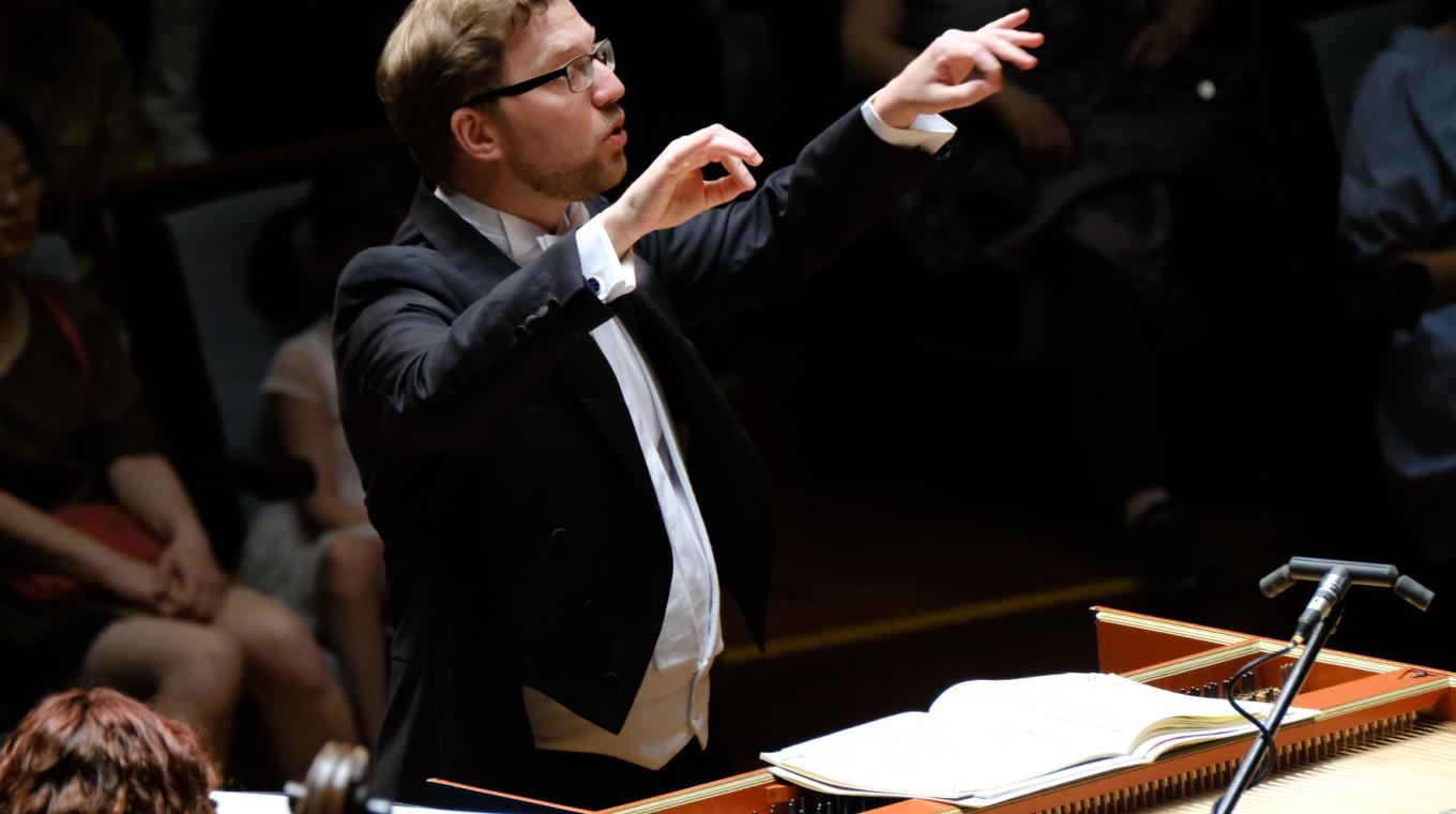 A man in a suit conducting an orchestra