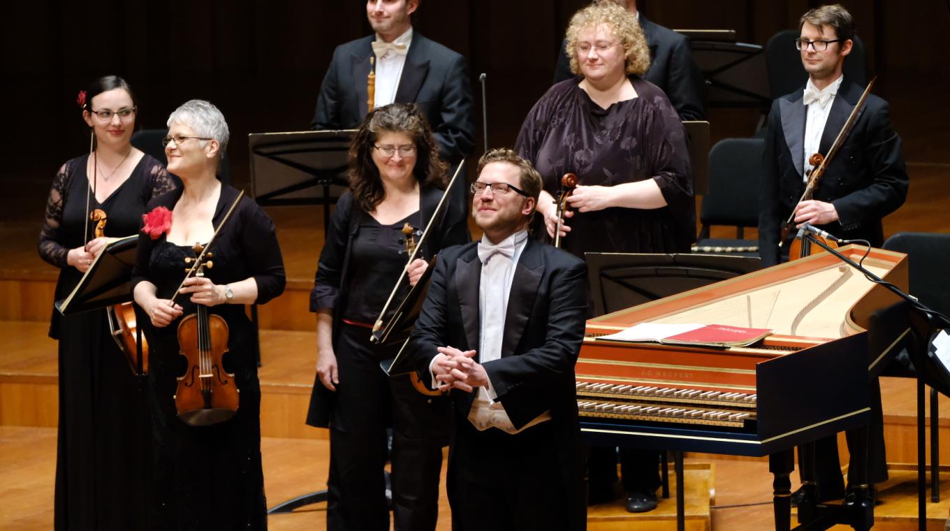 8 orchestral musicians and a piano facing an audience