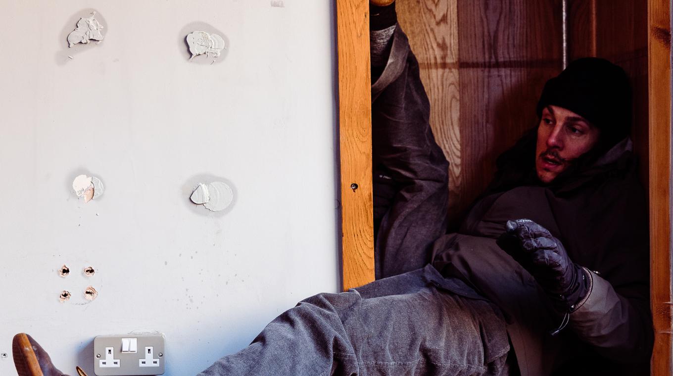 a man squashed into a cupboard space